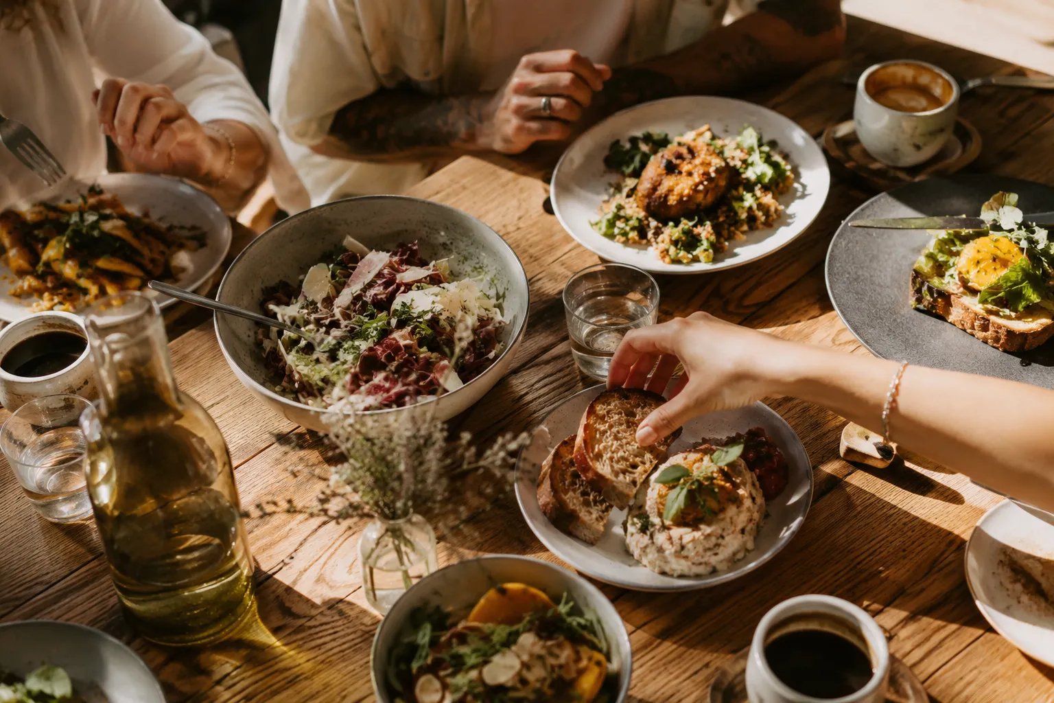 Mesa de brunch con platos compartidos y café.