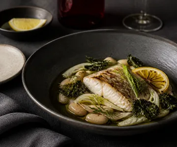 Plato de pescado con vegetales de estación.